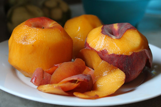 a plate three peaches one half peeled